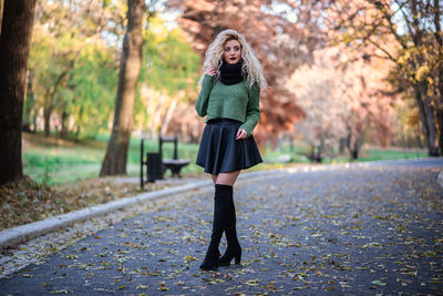 Full length of woman standing on footpath during autumn