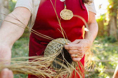 Hands of artisan weaving with esparto grass