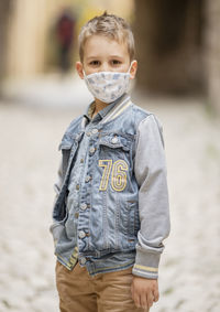 Portrait of boy wearing mask standing outdoors