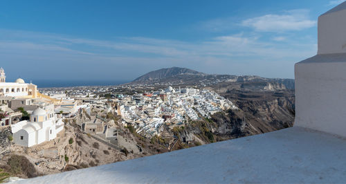 Aerial view of townscape and mountains against sky