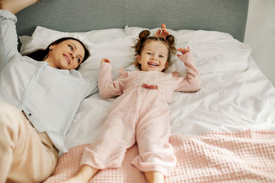 High angle view of young woman sleeping on bed at home