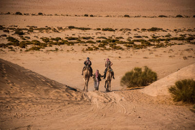 People riding horse in desert