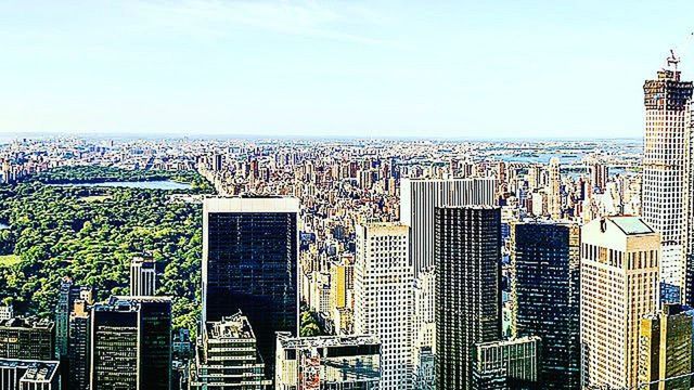 city, building exterior, cityscape, architecture, built structure, clear sky, skyscraper, modern, sea, sky, horizon over water, crowded, tall - high, office building, high angle view, outdoors, no people, day, copy space, city life