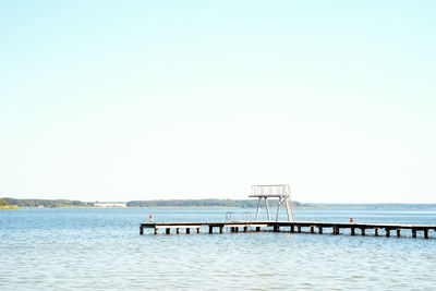 View of pier on sea against clear sky