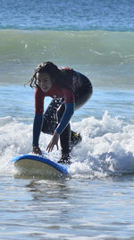 Full length of boy splashing water in sea