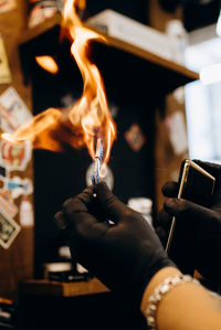 Close-up of hand holding burning candles