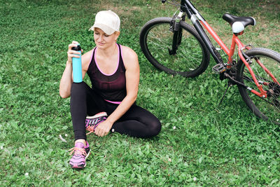 Low section of woman with bicycle on grassy field