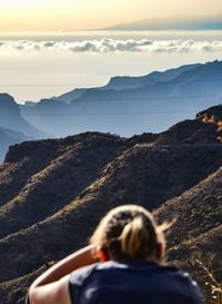 Rear view of woman on mountains against sky