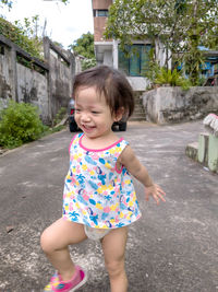 Full length of cute girl in front of building