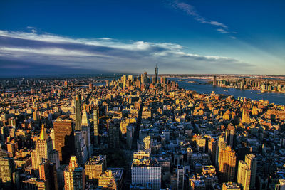 Aerial view of city buildings against cloudy sky