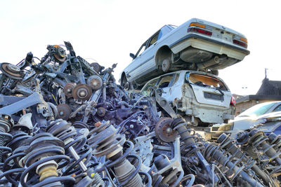 Stack of garbage on metal structure against sky