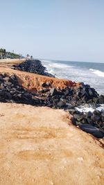 Scenic view of rocks on beach against clear sky