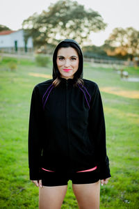 Portrait of smiling young woman standing on land