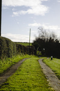 Road amidst field against sky