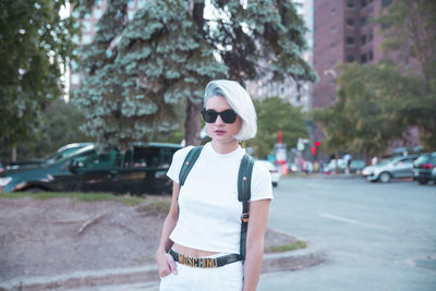 Young woman wearing sunglasses standing on road