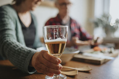 Senior woman holding glass with alcohol