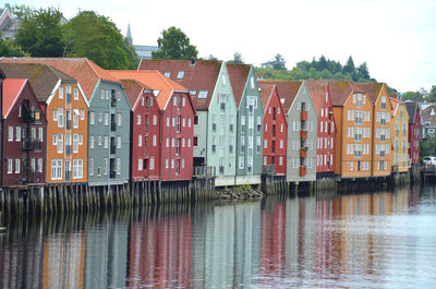 Buildings by river against sky