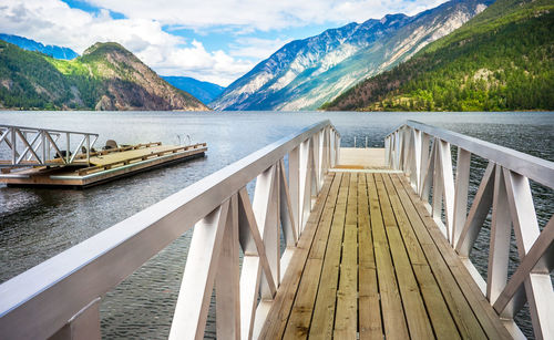 Wooden bridge over lake against sky