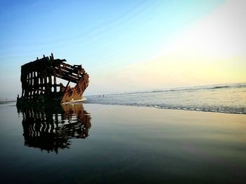 Silhouette of beach against sky during sunset
