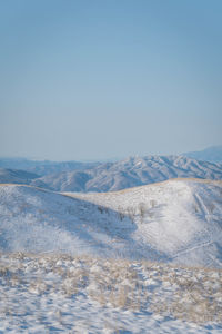 Scenic view of snowcapped mountains against clear sky