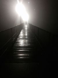 Illuminated walkway against sky at night