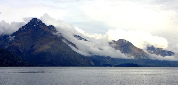 Scenic view of lake by mountains against sky