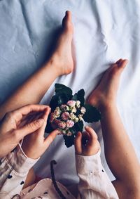 Low section of woman holding flower bouquet