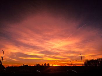 Silhouette road against sky during sunset