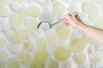 Female chef taking curd through ladle at dairy factory