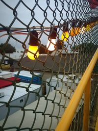 Close-up of yellow wire on chainlink fence