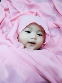 Portrait of cute baby lying on bed