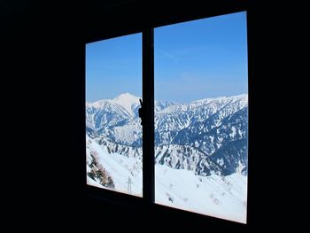 Snow covered landscape seen through window