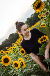 Low angle view of woman on sunflower field