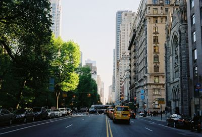 Traffic on road amidst buildings in city