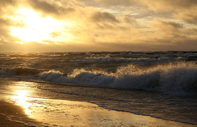 Scenic view of sea wave crashing against sky during sunset