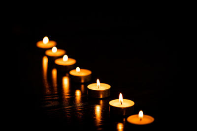 Close-up of lit candles in the dark