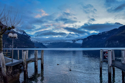 Scenic view of lake by snowcapped mountains against sky