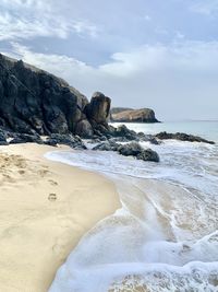 Scenic view of rocky beach against sky