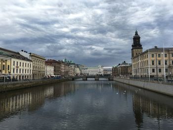 View of river in old town against cloudy sky