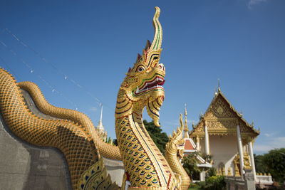 Low angle view of statue against temple against clear sky