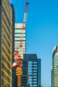 Low angle view of skyscrapers against clear blue sky