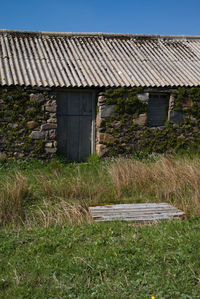 Old house on field against clear sky