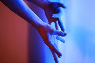 Cropped hands of person gesturing in illuminated room