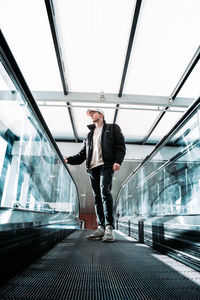 Full length of man standing on moving walkway