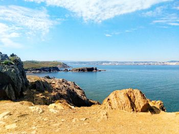 Scenic view of rocks on beach against sky