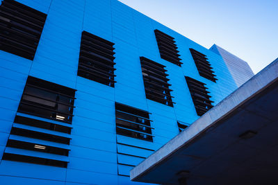 Low angle view of modern building against clear blue sky