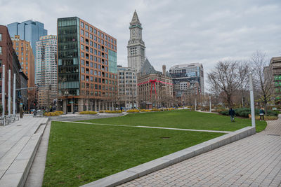 Park by buildings against sky in city