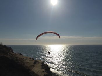 Sun shining through clouds over sea