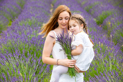 Beautiful woman with purple flowers on land