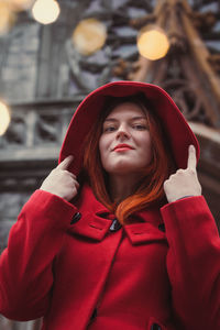 Close up confident woman in red coat on city street portrait picture